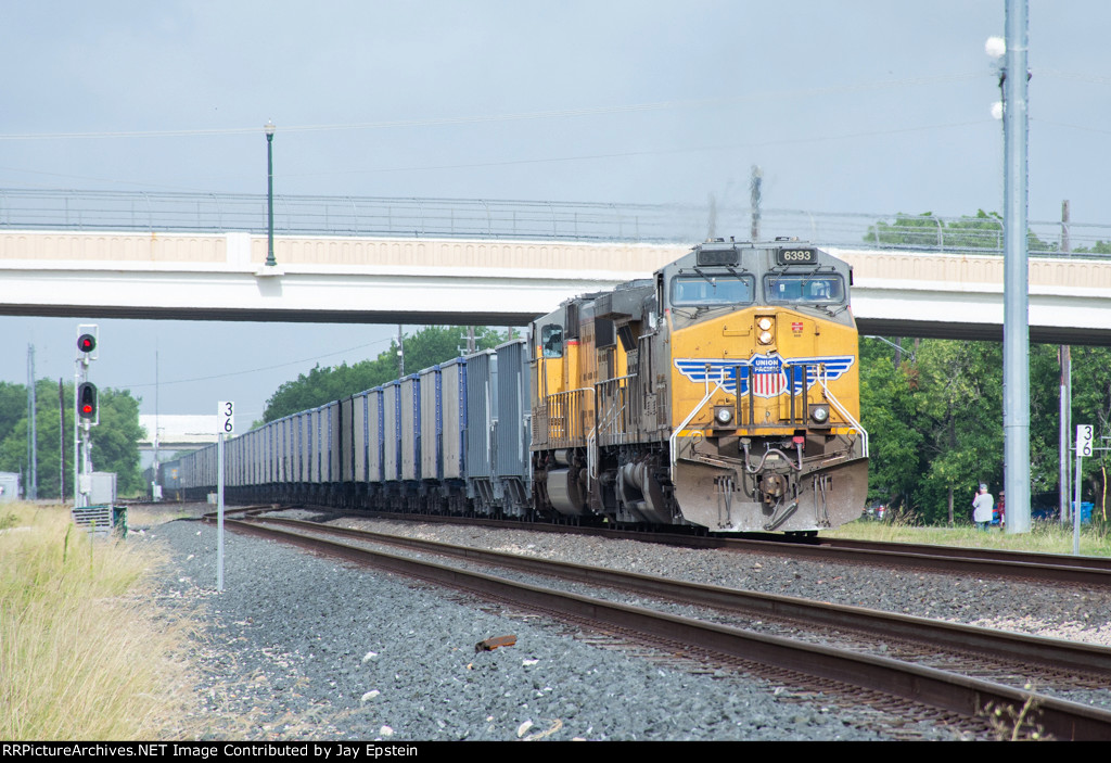 UP 6393 shoves an empty stone train under First Street